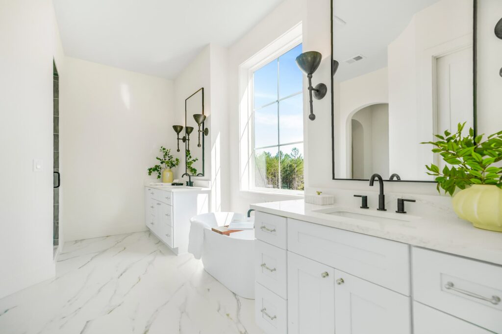Primary bathroom with freestanding tub and marble-look flooring in a Greenville semi-custom home
