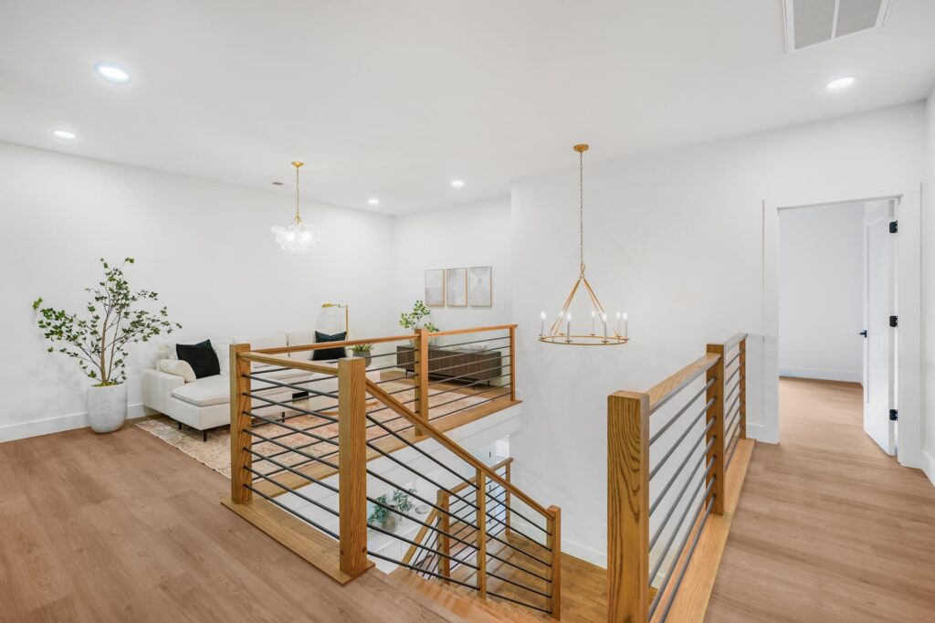 Open upstairs loft with iron and wood railing in a Greenville semi-custom home