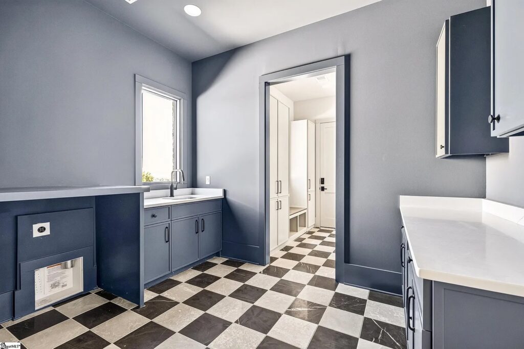 Navy mudroom and laundry with black-and-white checkerboard floor