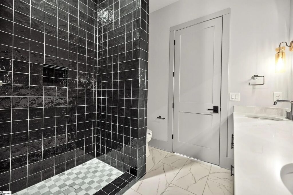 Guest bath shower with glossy black tile